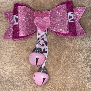Pink hearted bow with bell.